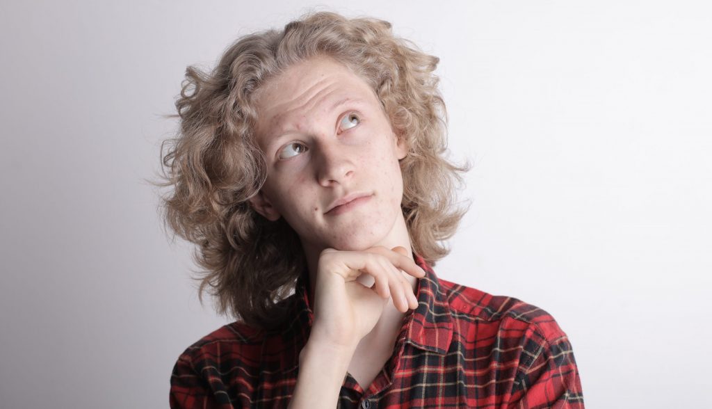 Pensive male teen on gray background