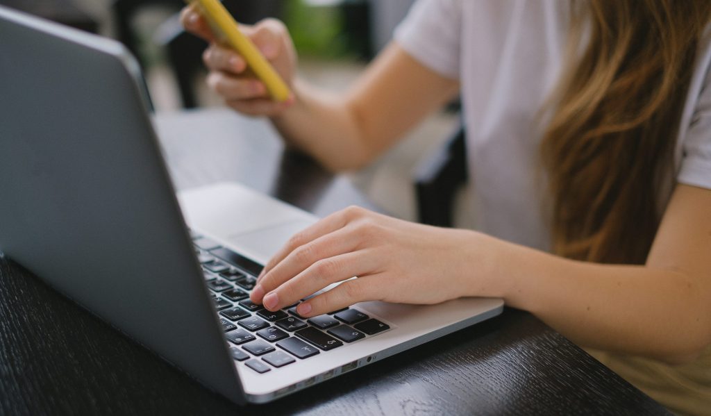 A person in white shirt using a laptop