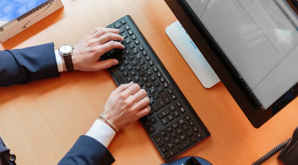 Person typing on computer keyboard